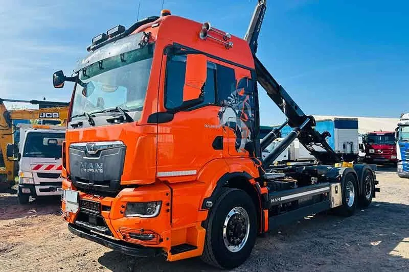 Orangefarbener MAN Lkw auf dem Hof