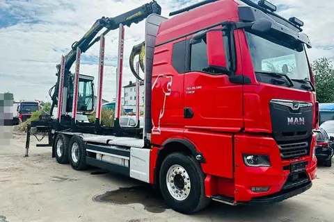 Roter MAN TGX Holztransporter mit Ladekran