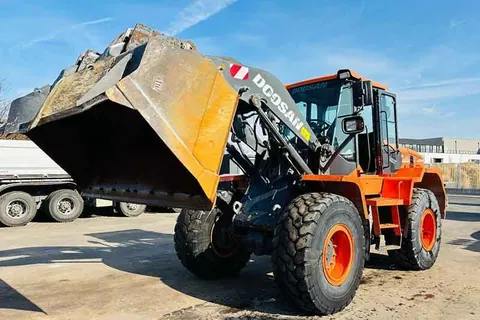 Orangefarbener Doosan Radlader mit angehobener Schaufel