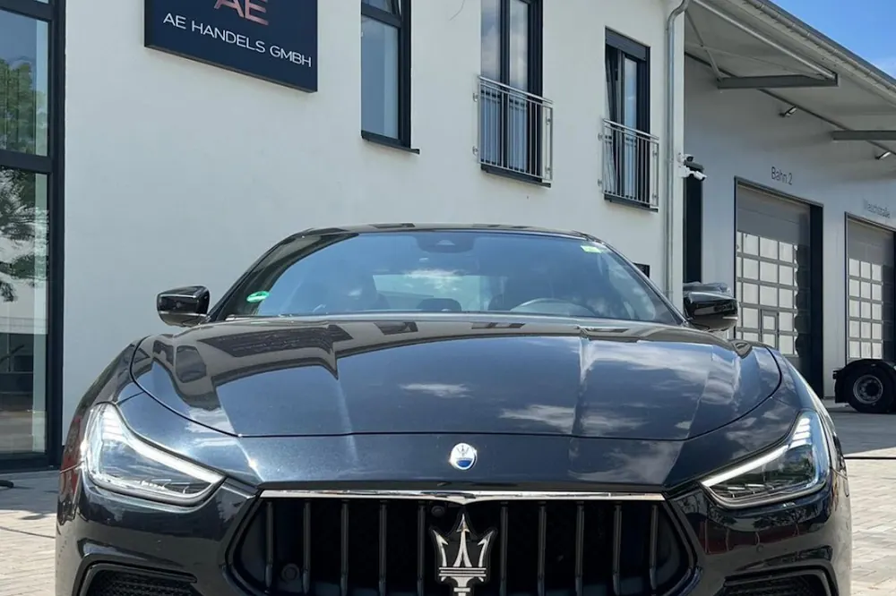 Schwarzer Maserati vor dem Firmengebäude mit AE Schild